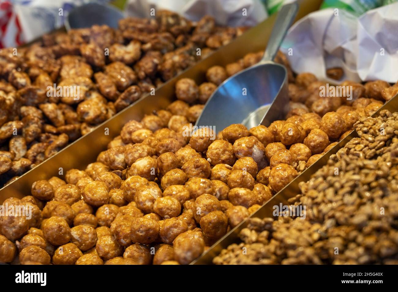 Candied almonds coated in browned, crunchy sugar, typical sweet food on a fun fair and Christmas market in Germany, copy space, selected focus, narrow Stock Photo