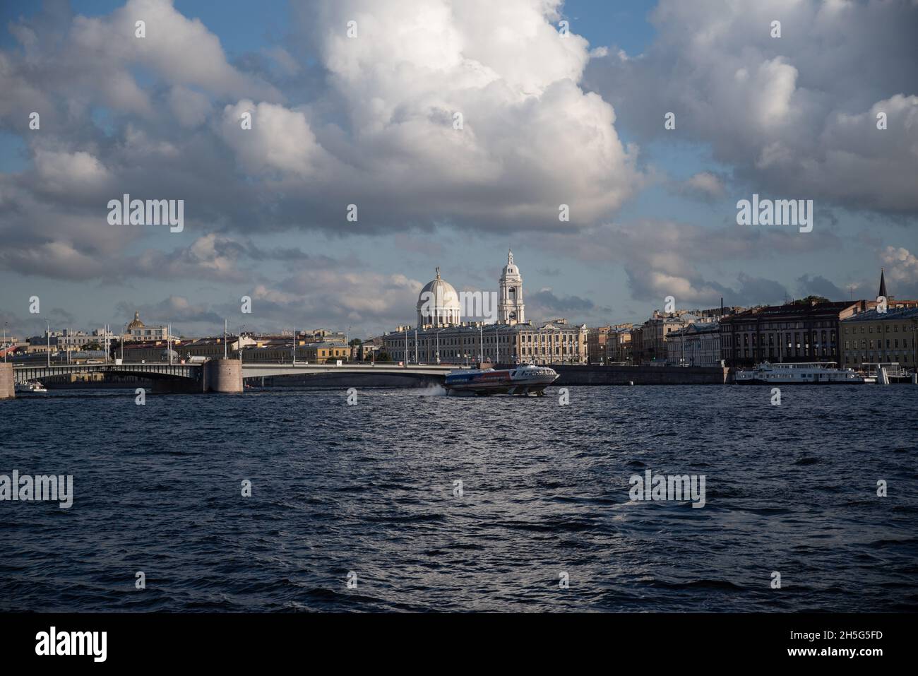 St. Petersburg, Russia - August 21, 2021:  Vasilievsky Island. 'Meteor' boat on Neva river with Church of St. Catherine the Great Martyr and Tuchkov b Stock Photo