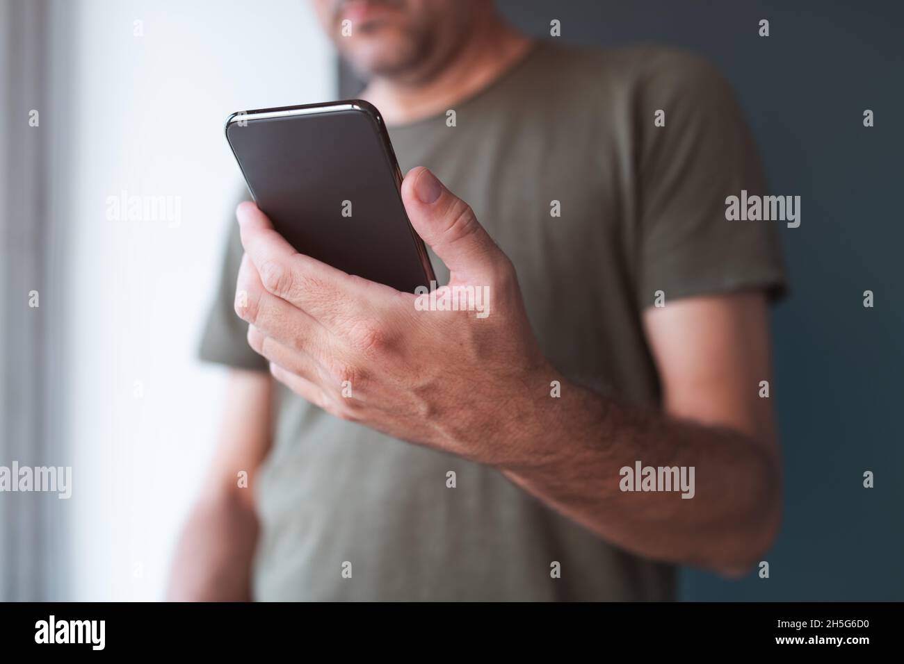 Man reading text message on mobile smart phone, selective focus on hand and device Stock Photo