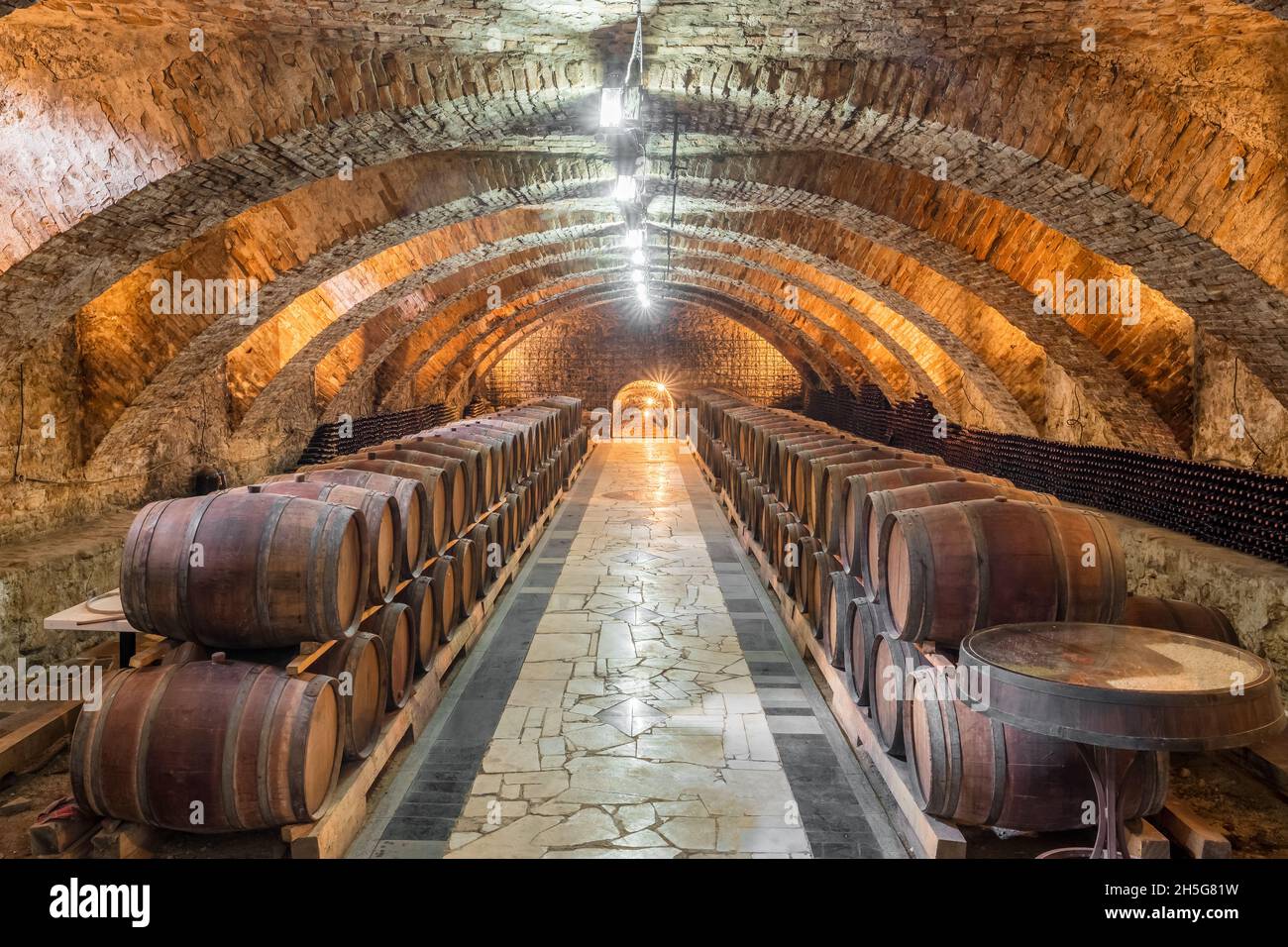 Old wooden barrels with wine in the ancient medieval cellars Stock