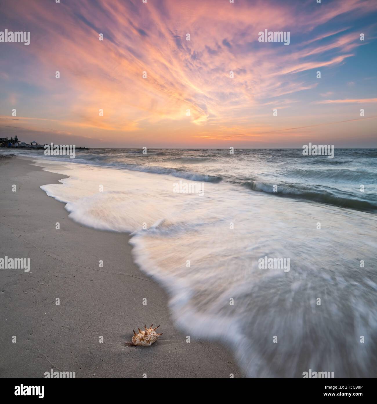 Fine landscape with sea views and majestic dawn sky, shell on sand Stock Photo