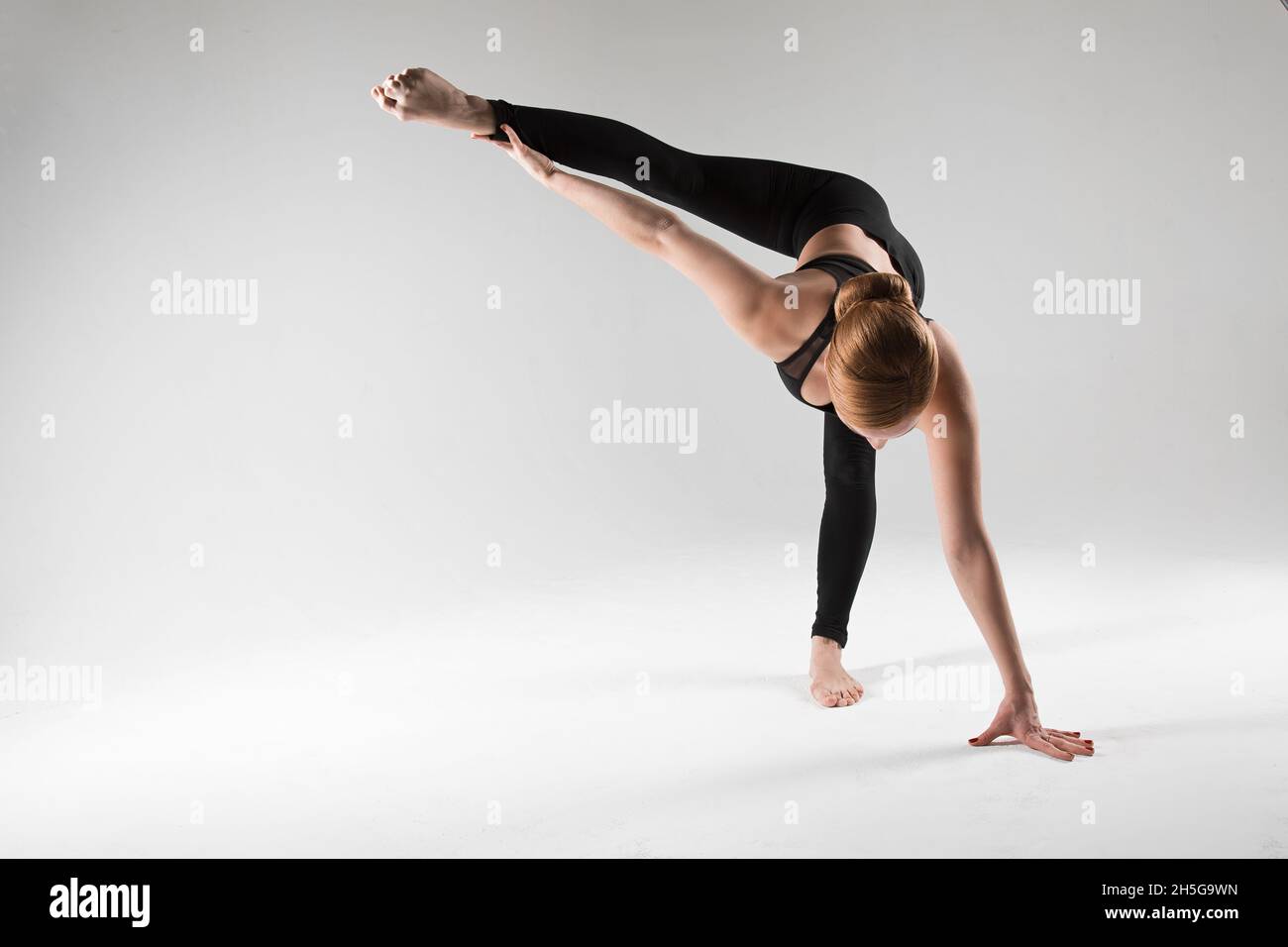 A professional yoga and pilates trainer shows exercises from yoga, pilates, stretching and other types of fitness on a mat with equipment, with fitnes Stock Photo