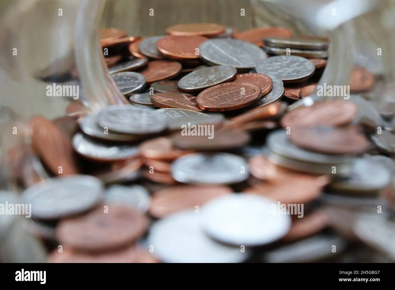 Closeup of coins in a glass jar Stock Photo