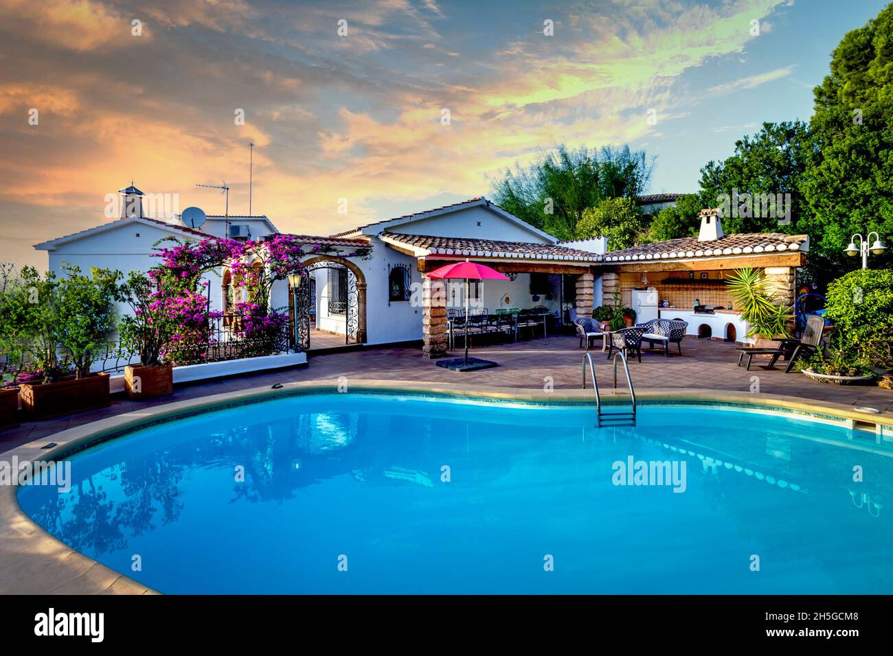 Mid-Mediterranean villa with pool, garden and dramatic sky. Stock Photo