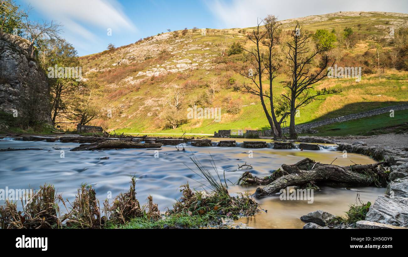 Water seen flowing around and over some of the stepping stones at Dovedale after some heavy rainfall in November 2021. Stock Photo