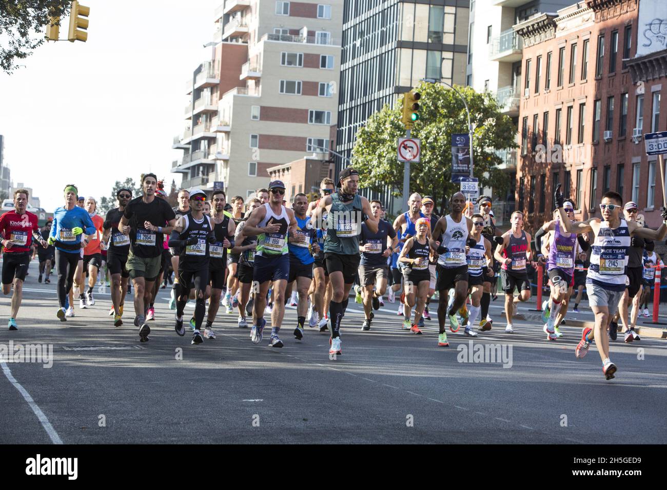 50th anniversary New York City Marathon race in 2021 after no race in 2020 do to the Covid-19 Pandemic. Large pack of runners run with a pace setter up 4th Avenue around mile 6 of the race in Brooklyn. Stock Photo