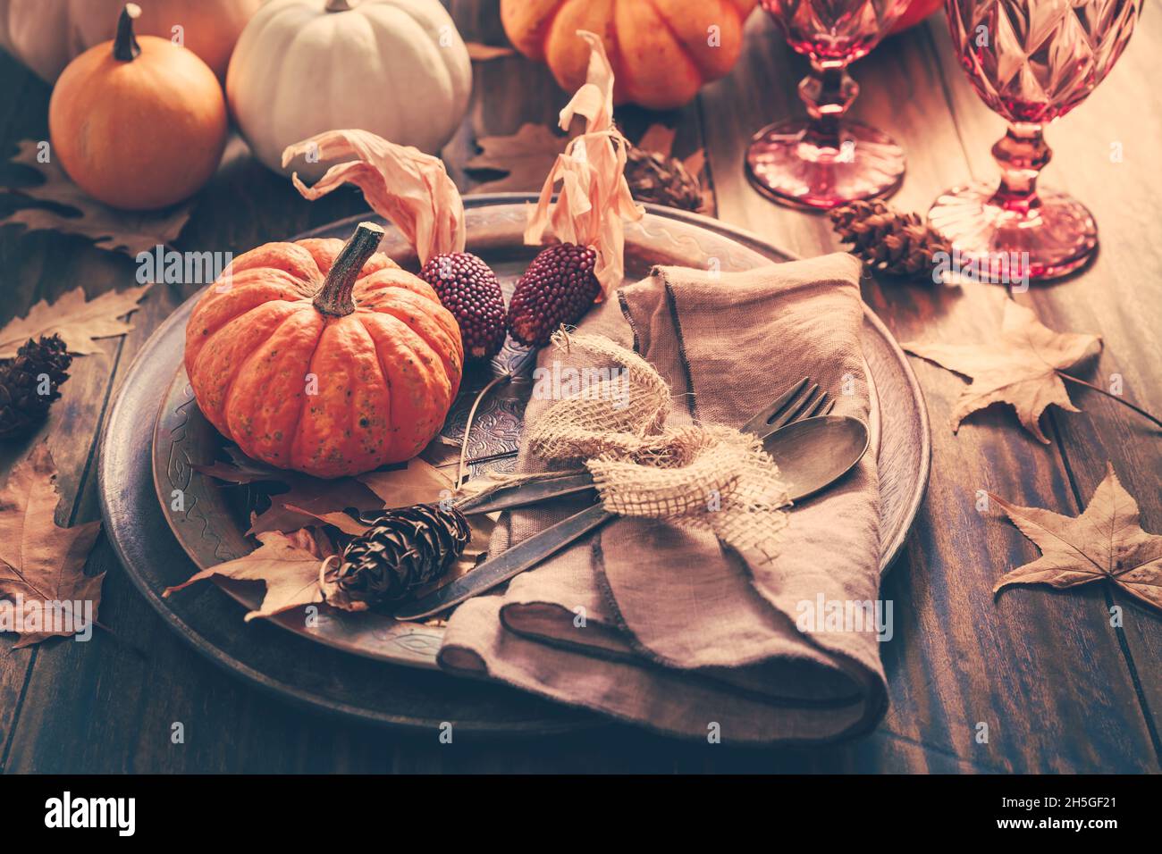 Place setting for Thanksgiving with pumpkins and autumn leaves in vintage style Stock Photo