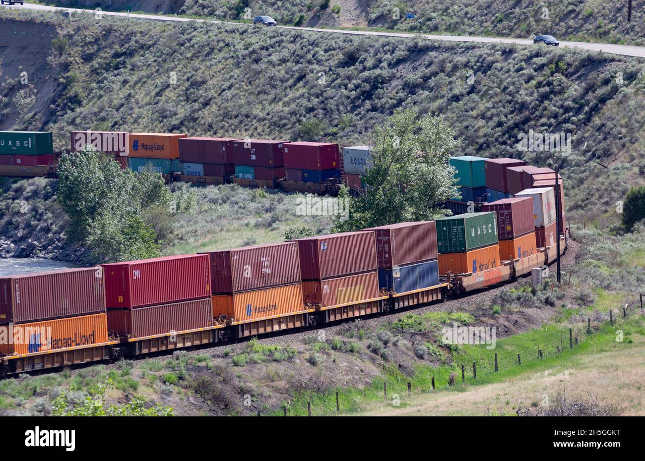 A transport train with colourful shipping containers runs along the ...