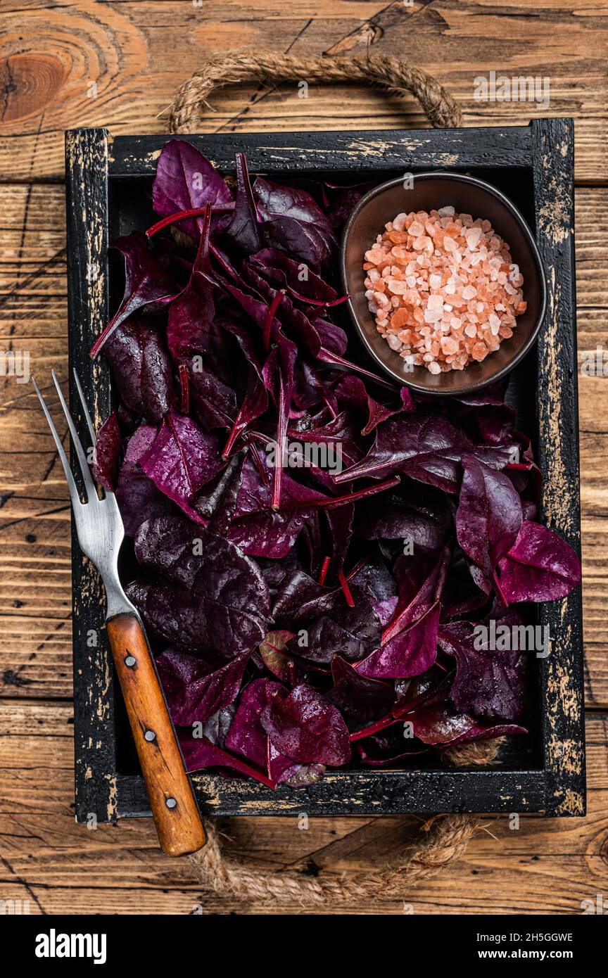 Fresh raw Swiss Ruby or red chard salad Leafs in a wooden tray. wooden background. Top view Stock Photo