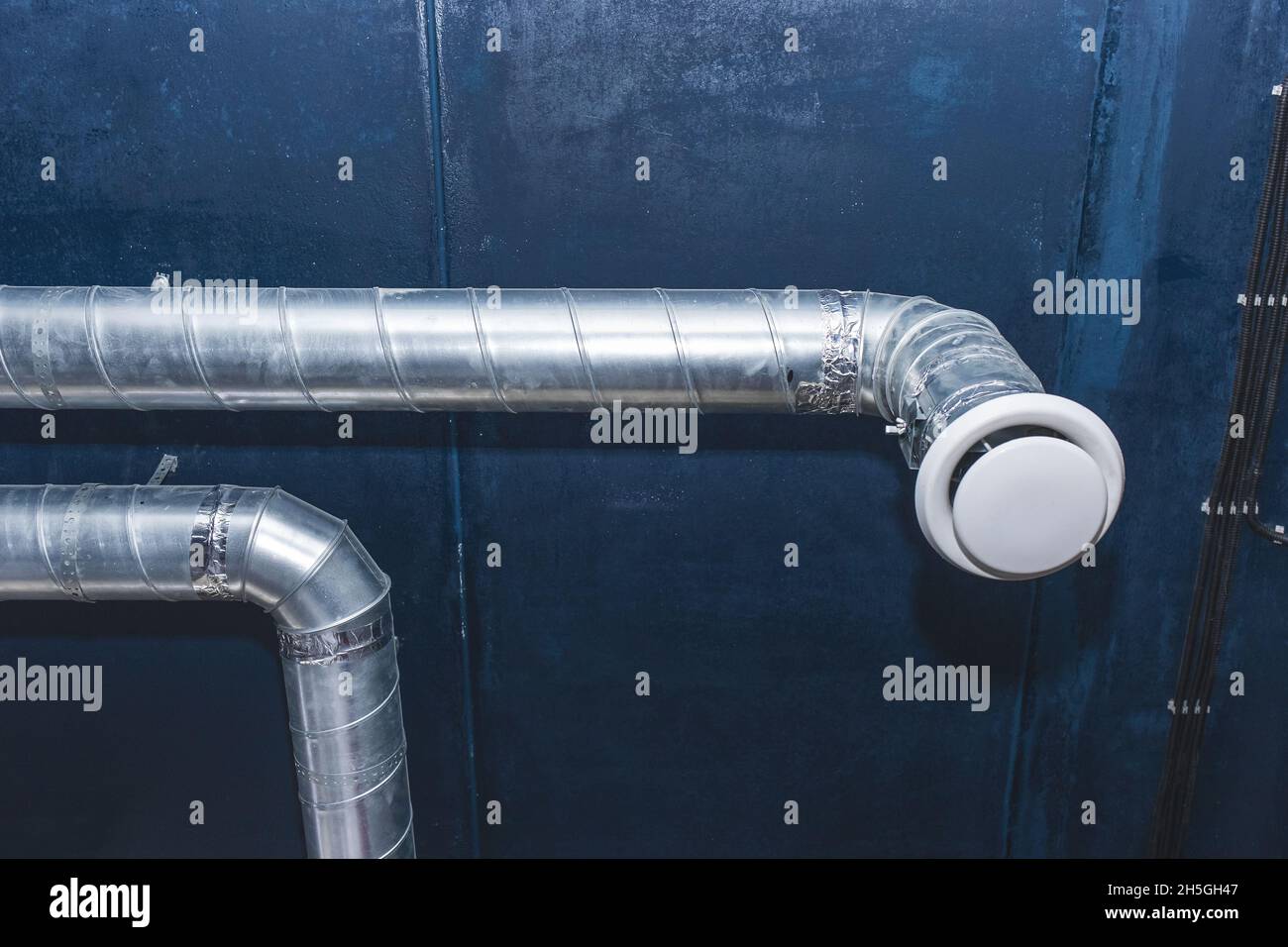 Ventilation pipe system at the ceiling of an industrial enterprise or plant premises. Stock Photo