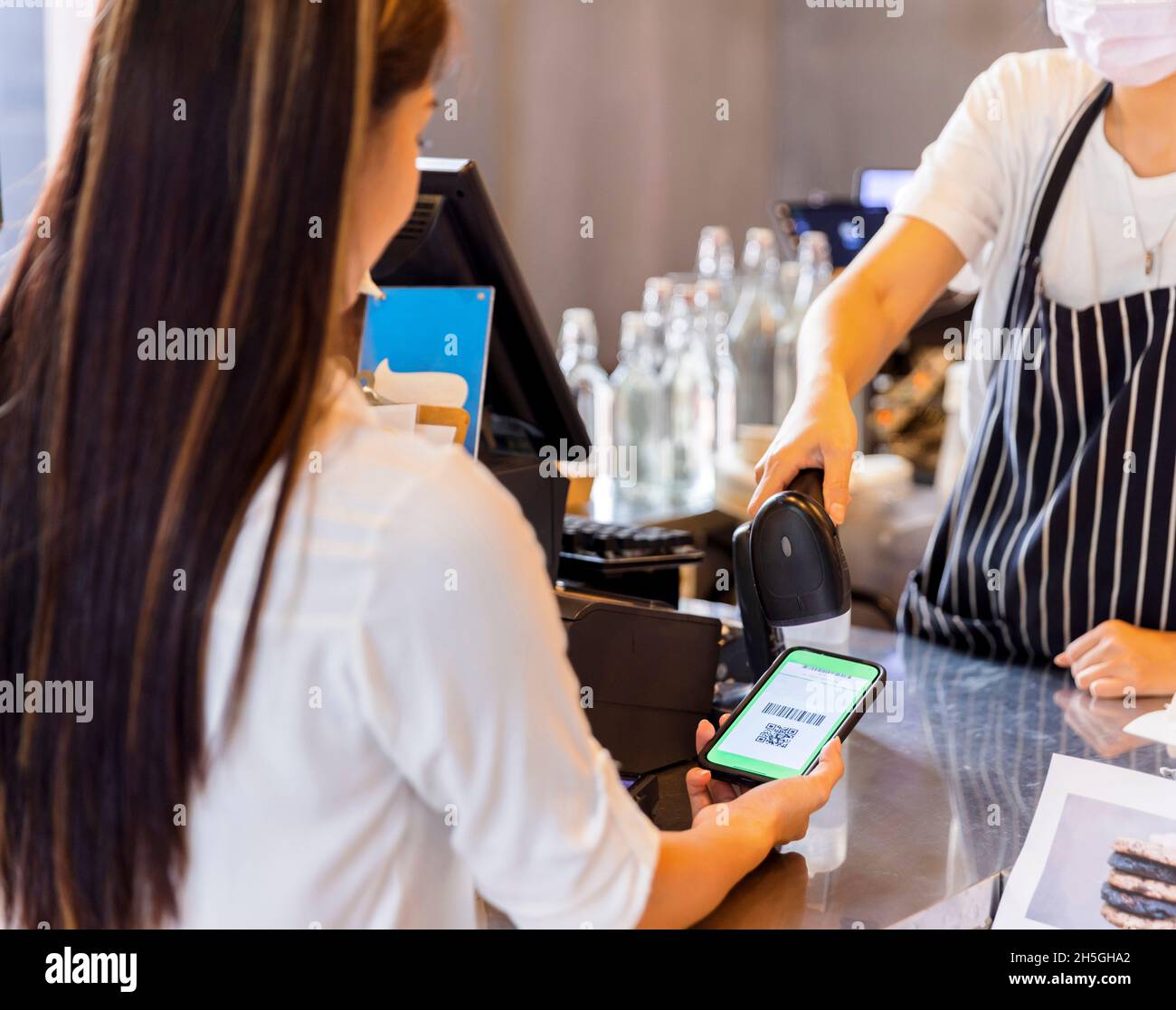 Technology and Payment concept. Young woman using wireless or contactless payment by smart phone. Stock Photo