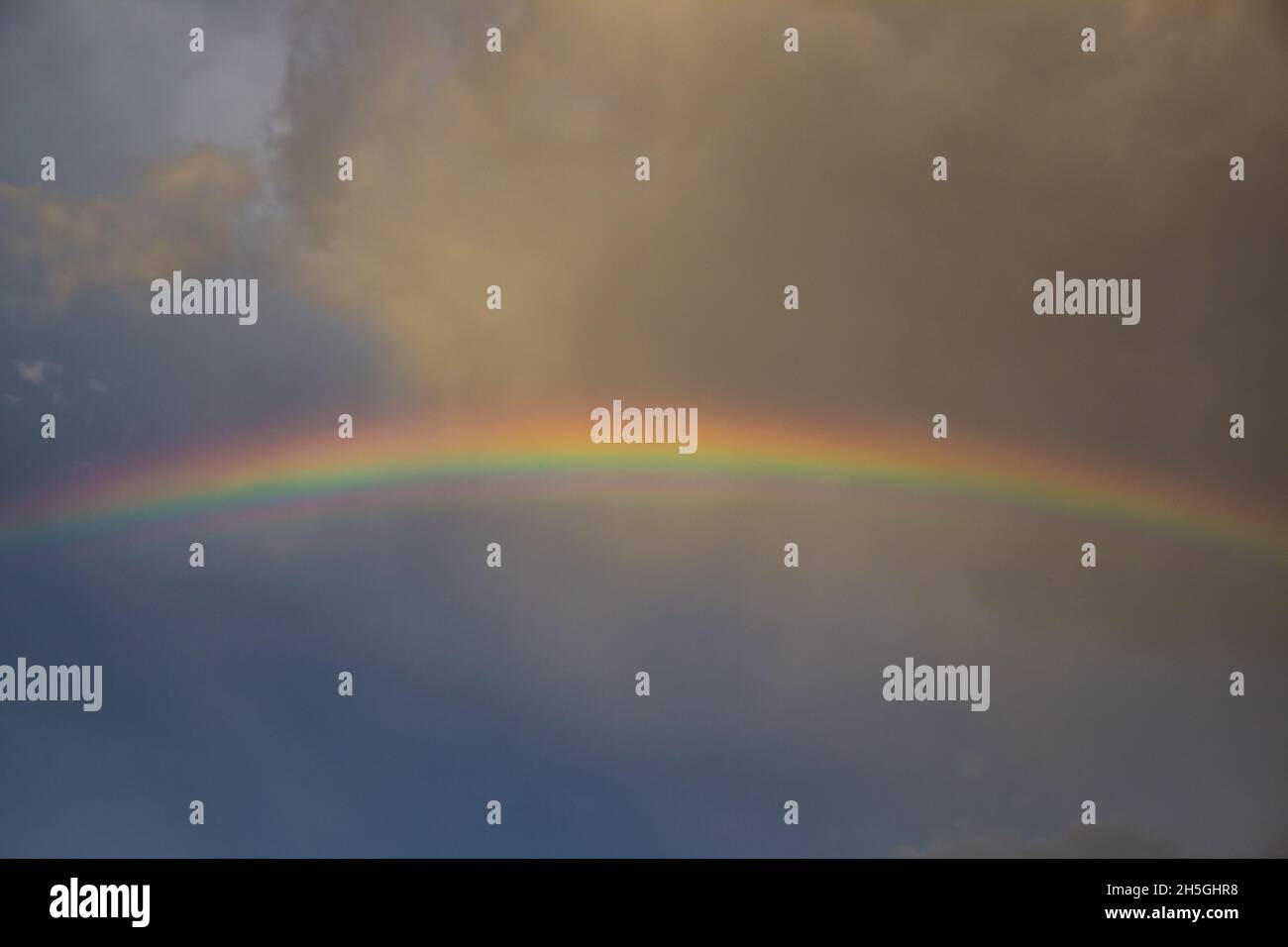 Rainbow over stormy sky Stock Photo - Alamy