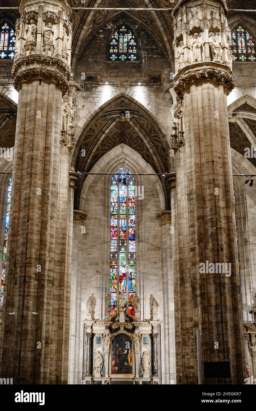 Colored stained glass windows against the huge carved marble columns of ...