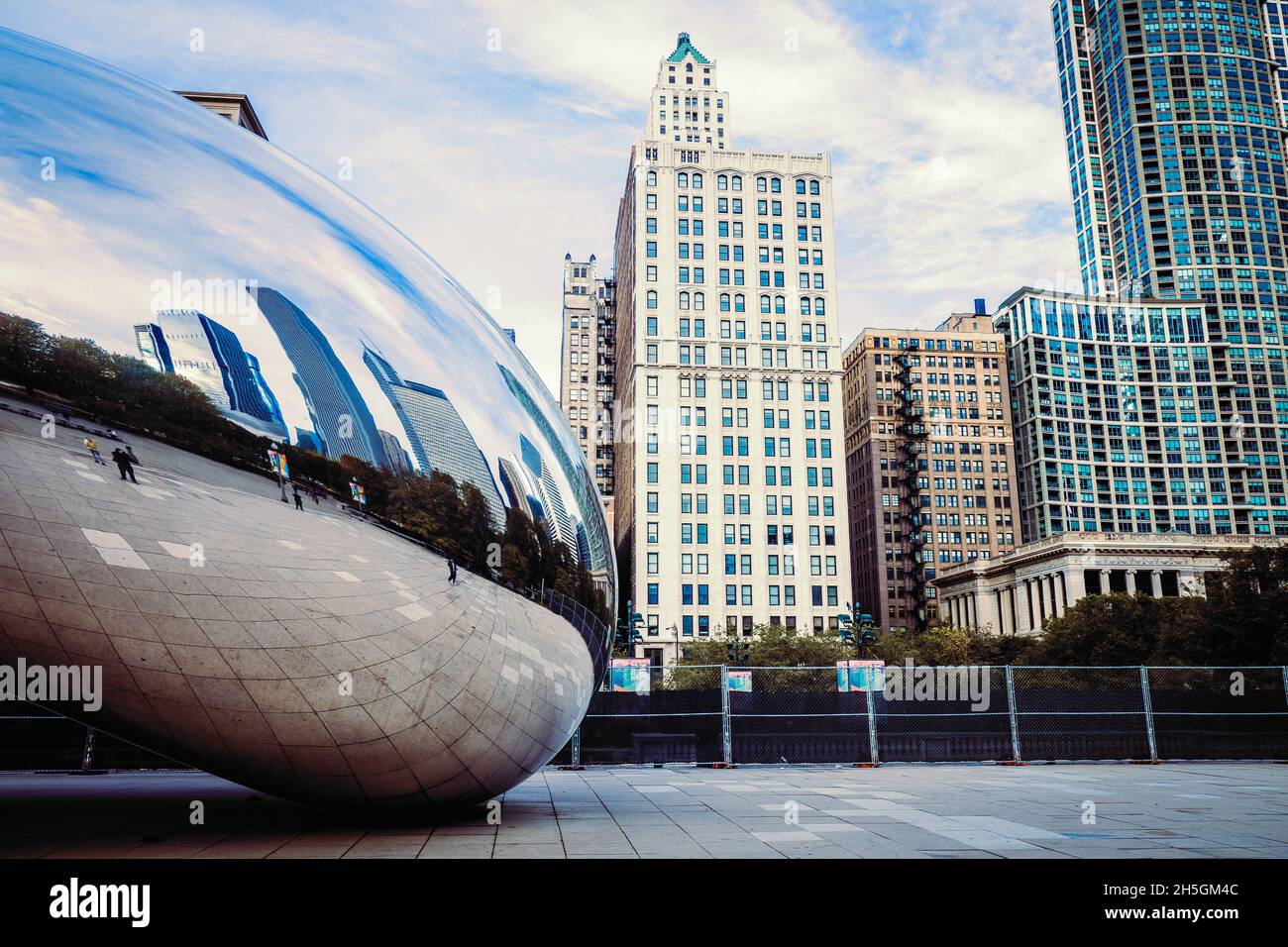 Only few people around Sir Anish Kapoor's sculpture Cloud Gate, nicknamed The Bean, in front of the skyline of Chicago, IL, USA Stock Photo