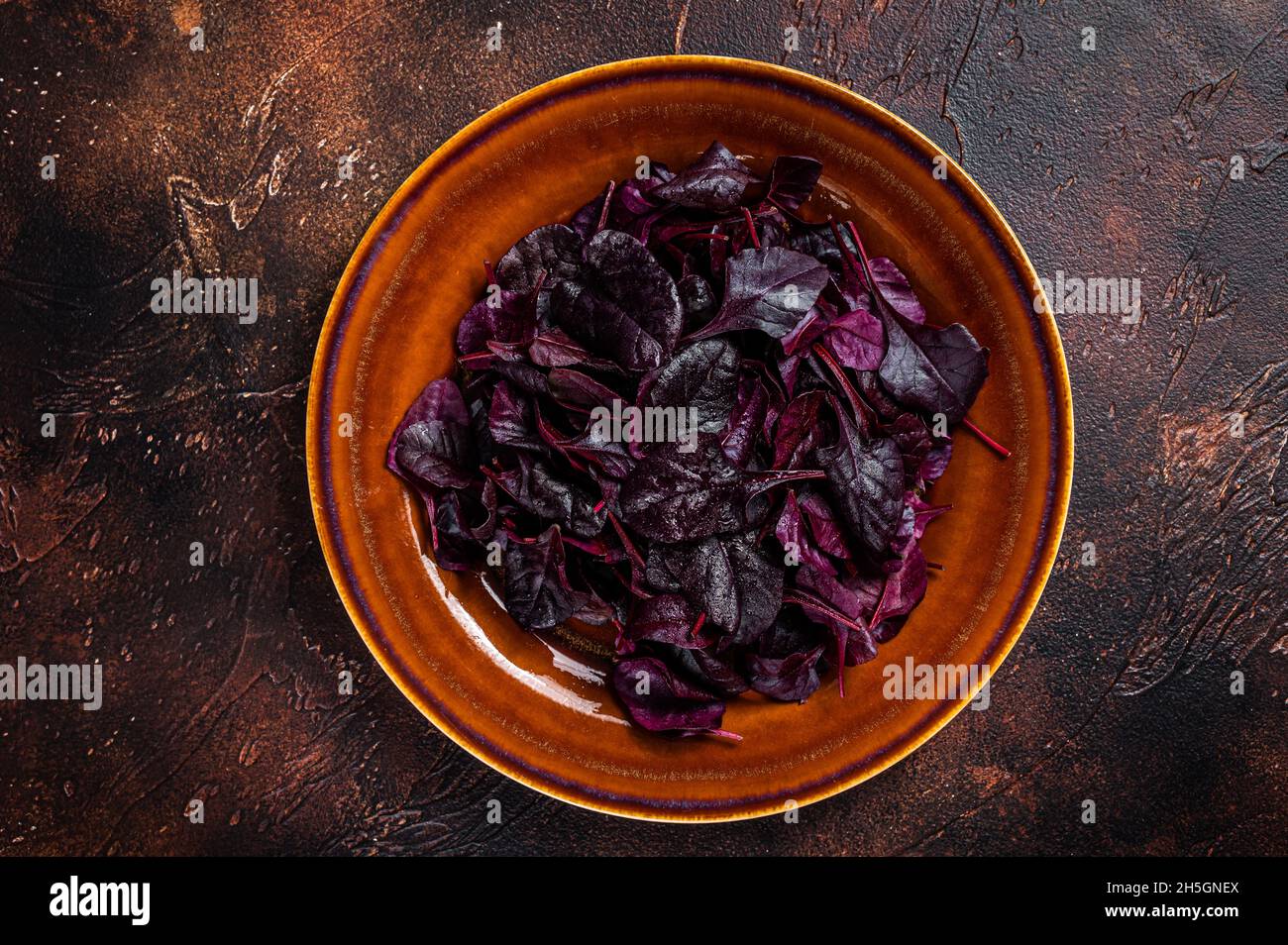 Raw Ruby or red chard salad Leafs on a rustic plate. Dark background. Top view Stock Photo