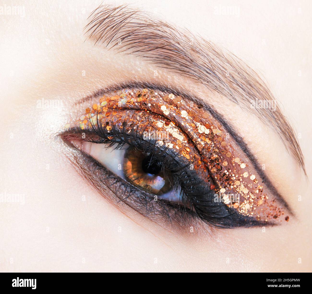 Closeup shot of female face with vogue golden shining eyes makeup