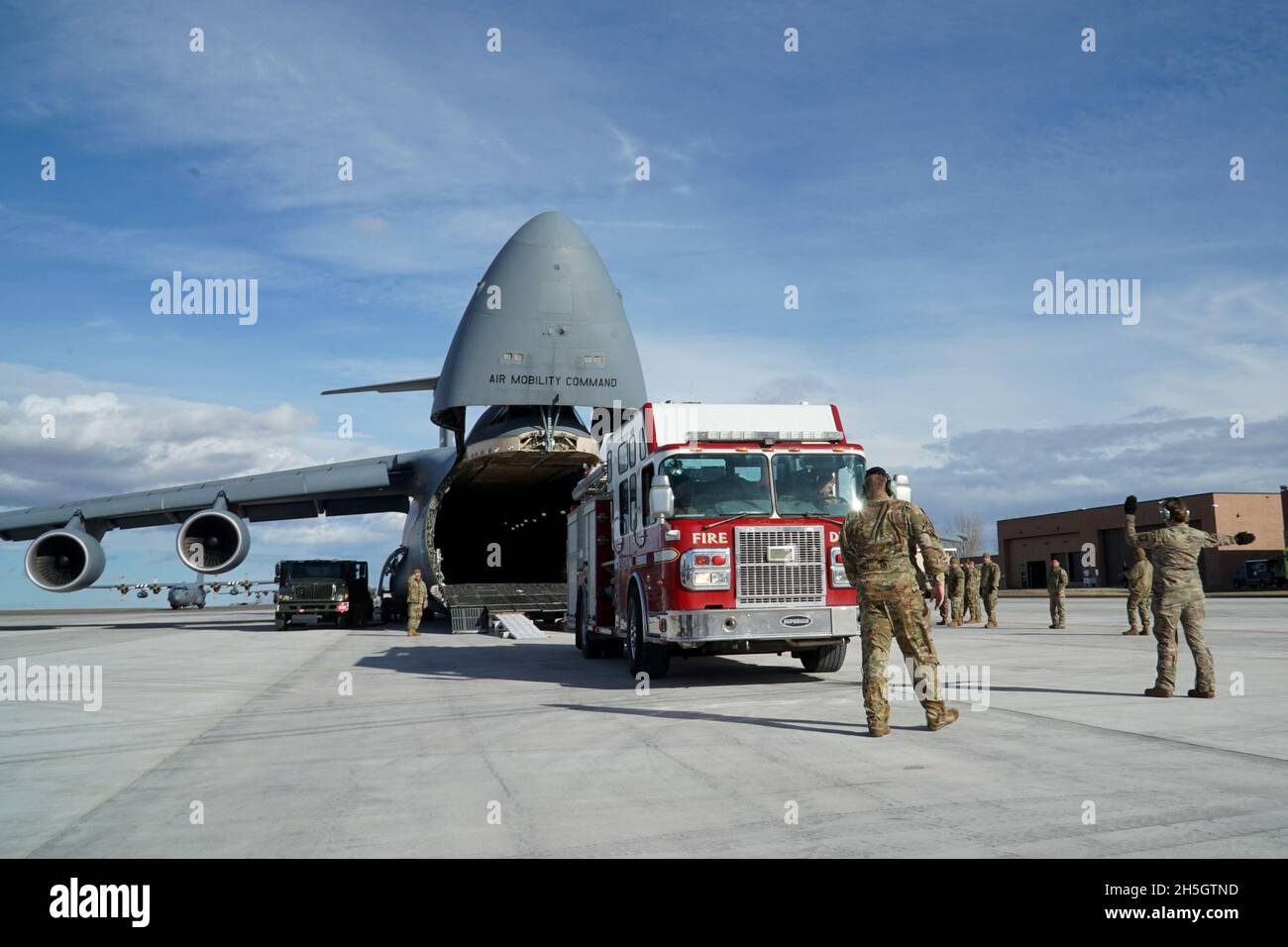 Members of the 120th Airlift Wing and the 60th Air Mobility Wing load a Spartan Guardian fire truck onto a U.S. Air Force C-5M Super Galaxy at the Montana Air Guard Base, Great Falls, Mt, Nov. 6, 2021. Airmen from the 120th Airlift Wing and 60th Air Mobility Wing load three fire trucks onto a C-5M Super Galaxy for delivery to Belize, as part of the Defense Department’s Denton Program, which provides humanitarian aid supplies all over the world.(U.S. Air National Guard photo by Tech. Sgt. Lindsey Soulsby) Stock Photo