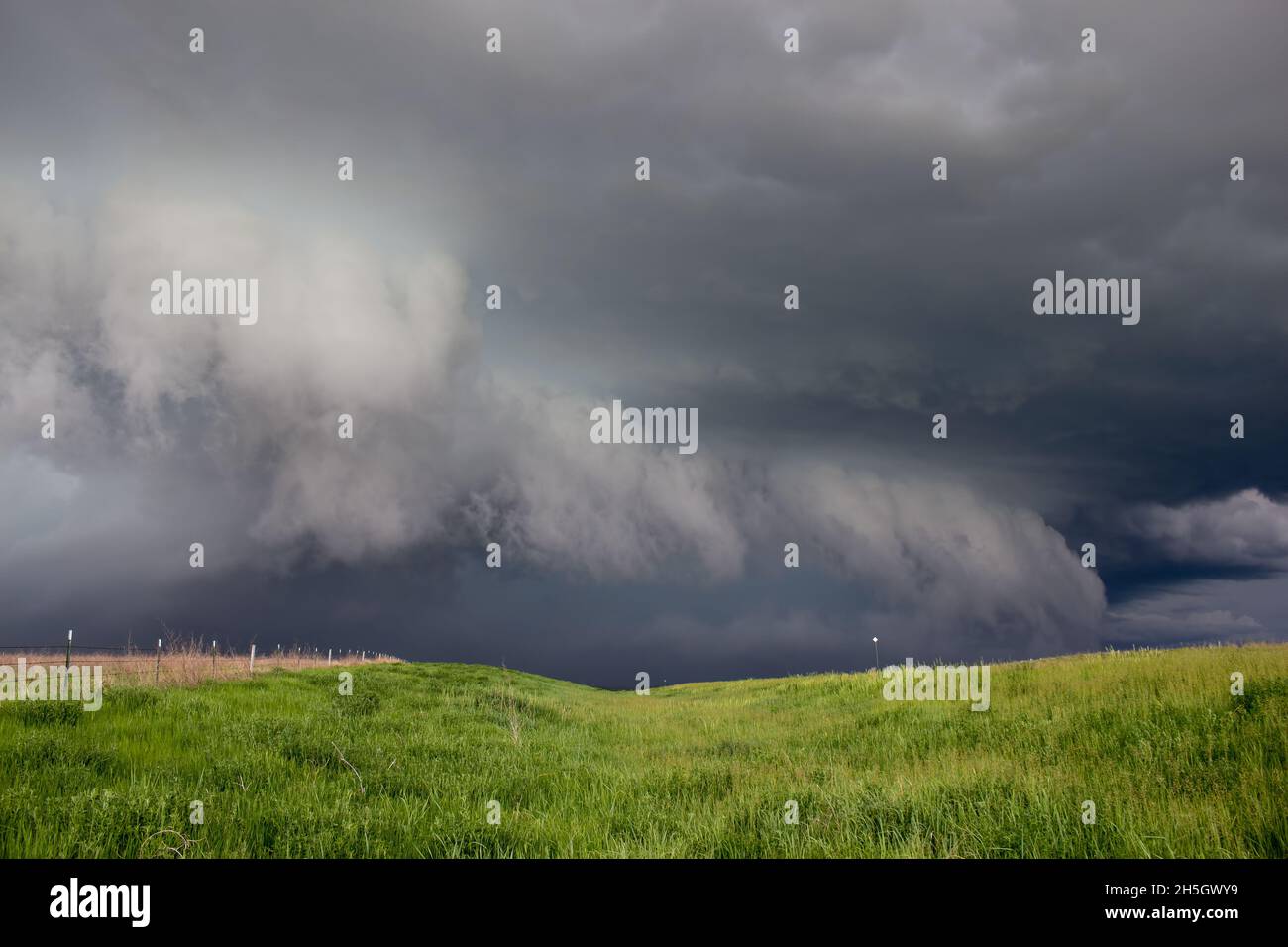 A dark storm advances, featuring a ragged shelf cloud with rain and ...