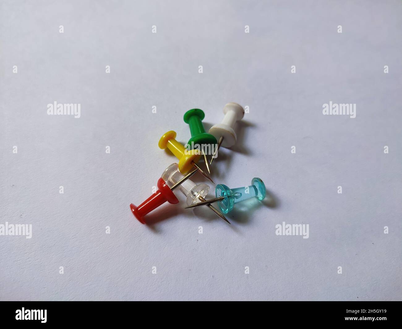 Pile of drawing pins on white background Stock Photo - Alamy