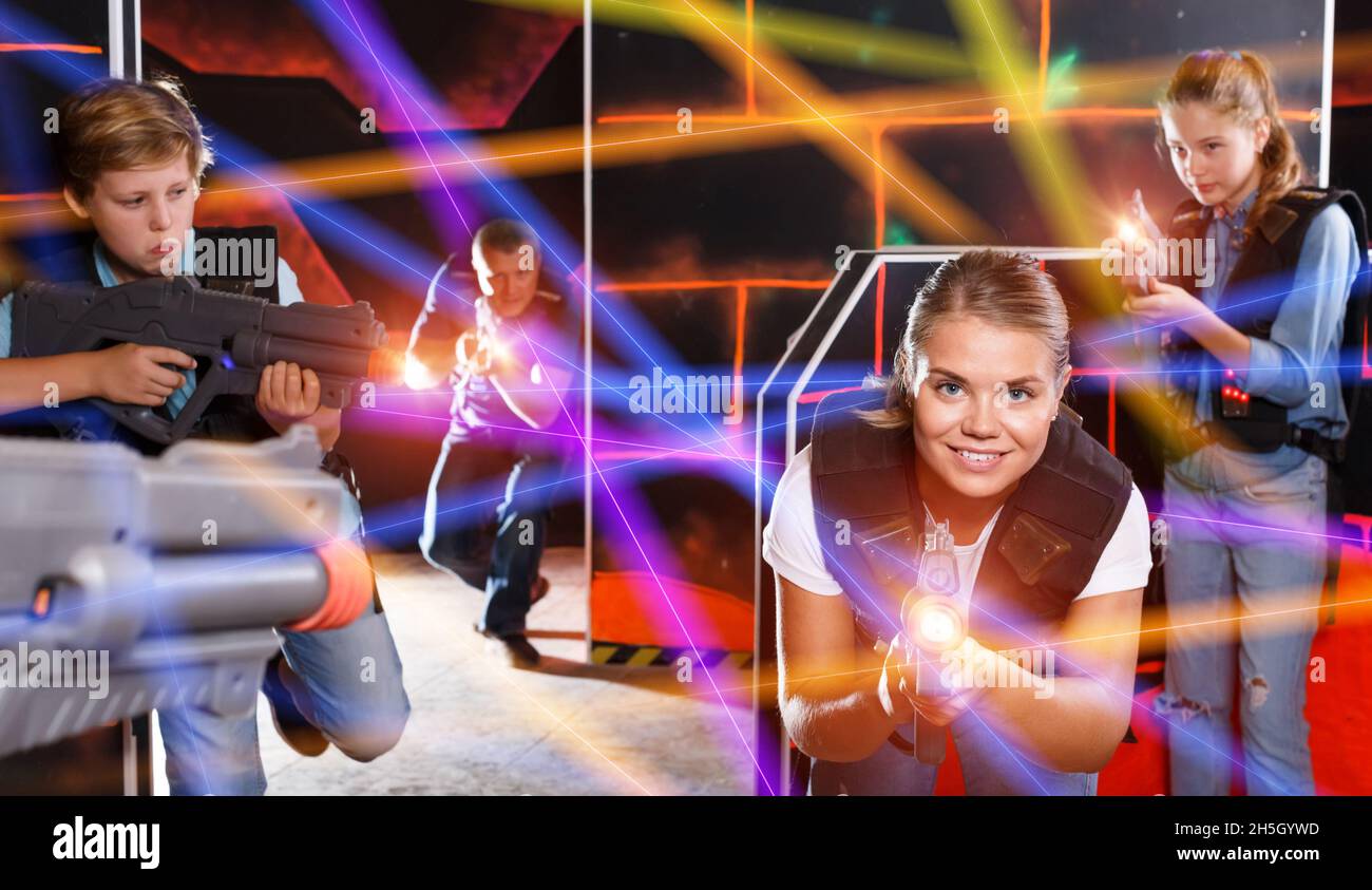 Excited kids and theirs parents playing laser tag game in dark r Stock  Photo - Alamy