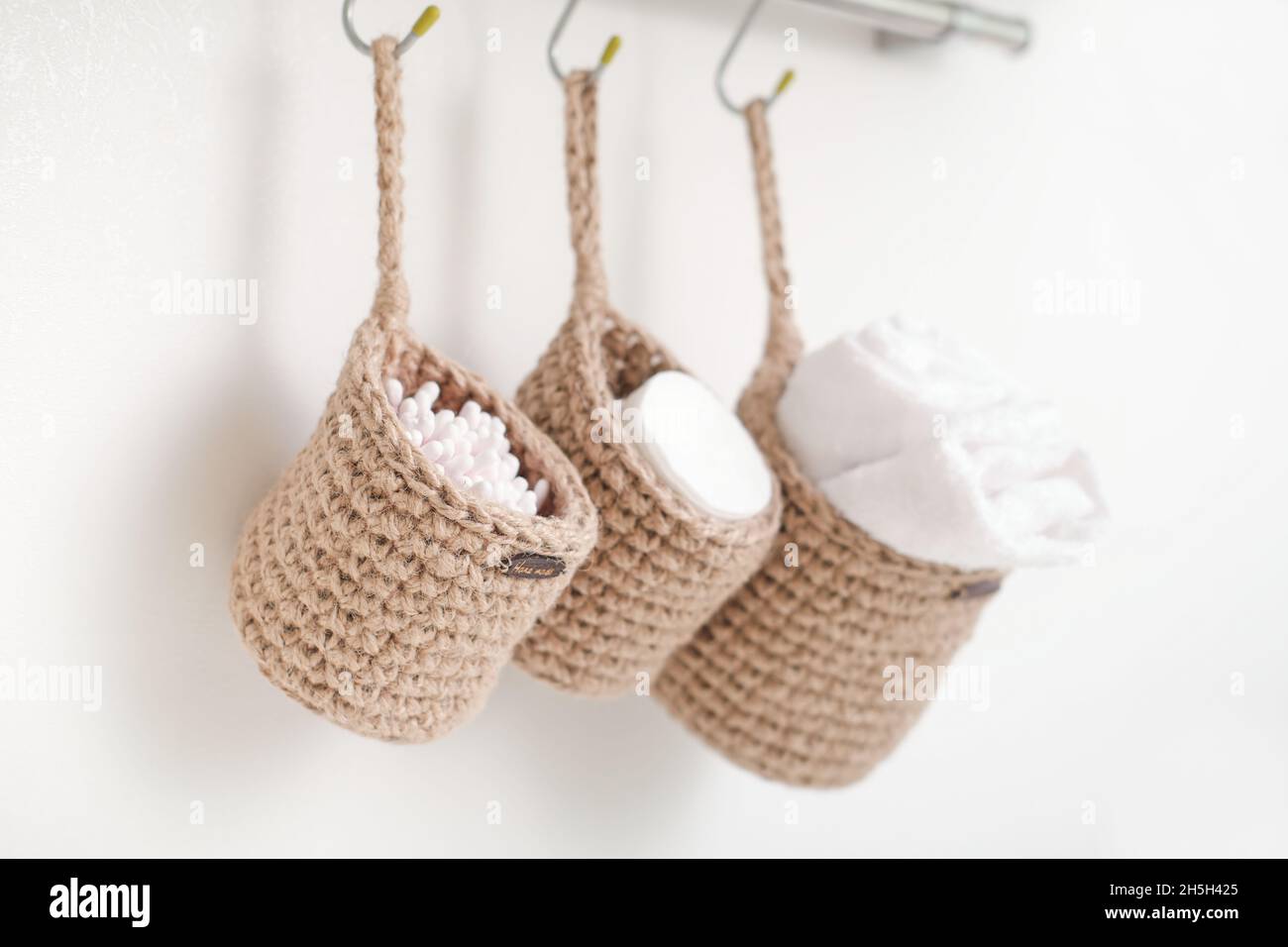wicker mini baskets hanging on a wall. toiletry storage in bathroom