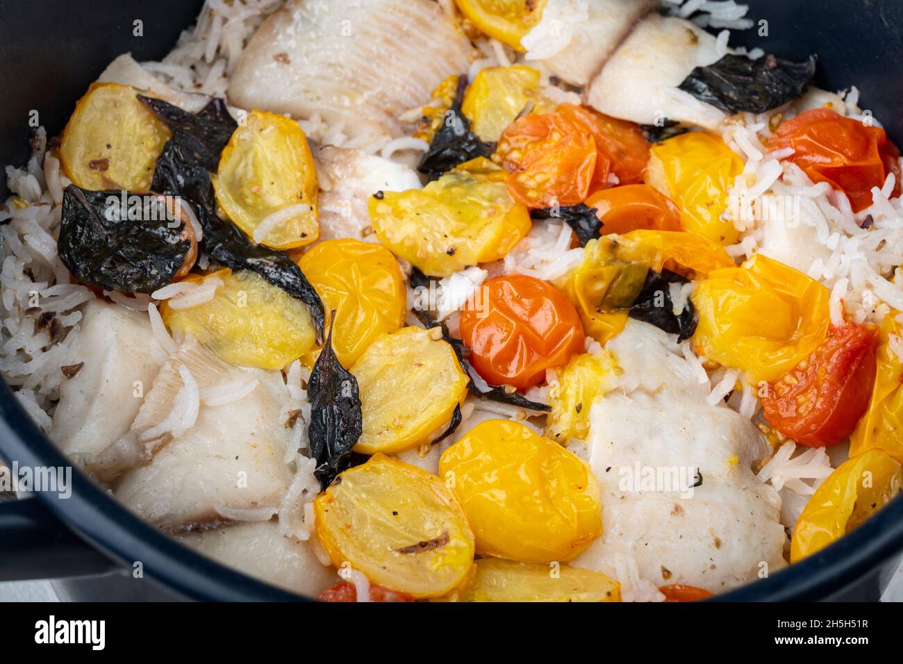 White tilapia fish, with basmati rice and cherry tomatoes Stock Photo