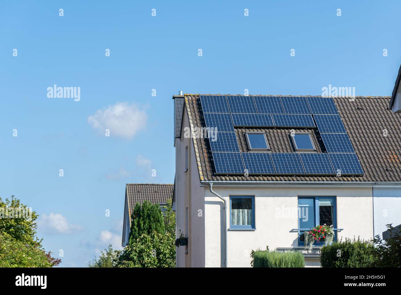 Beautiful view of a tree house roof with solar panels against a sunny ...