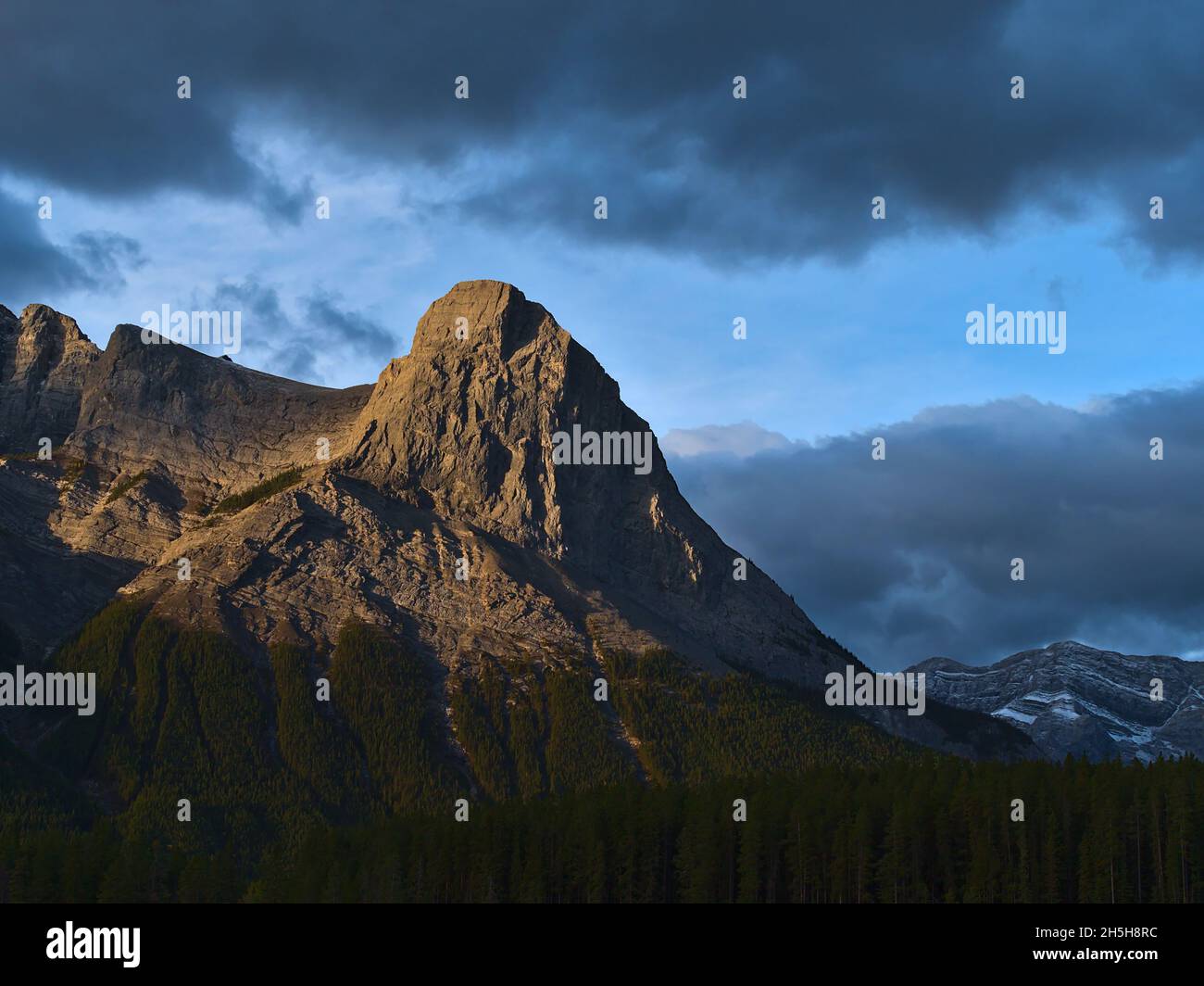 View of the top of popular hiking destination Ha Ling Peak near Canmore, Kananaskis Country, Alberta, Canada in the morning light with cloudy sky. Stock Photo