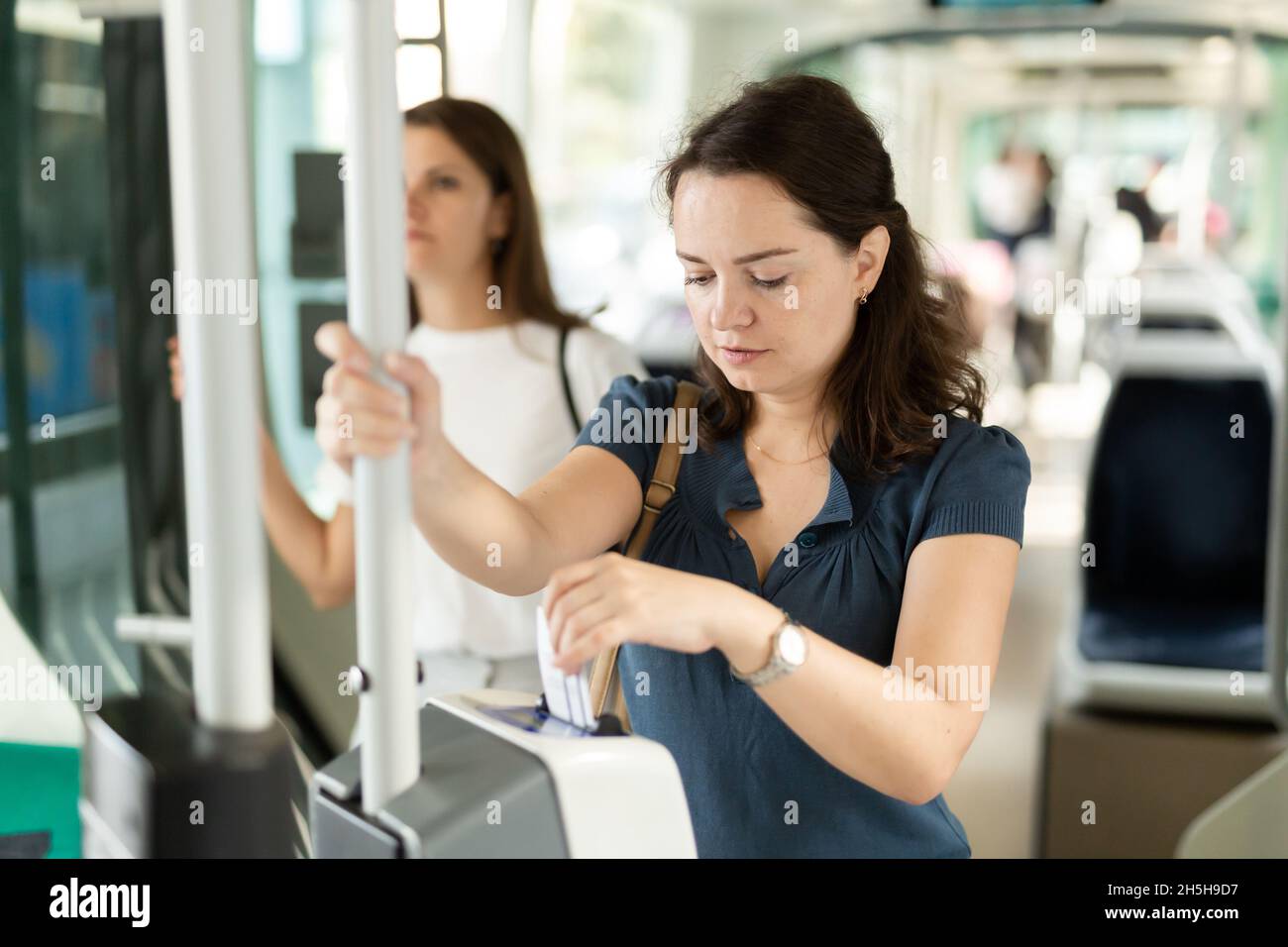 Woman validating ticket in public transport Stock Photo