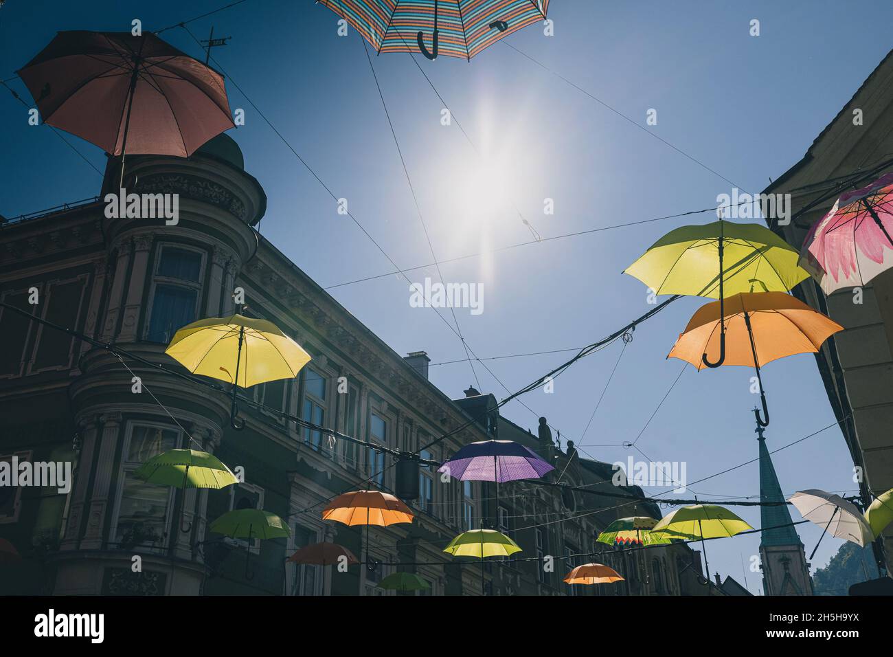 Bunch of umbrellas floating above the streets in Celje.Street decorations in the centre of an old city. Stock Photo