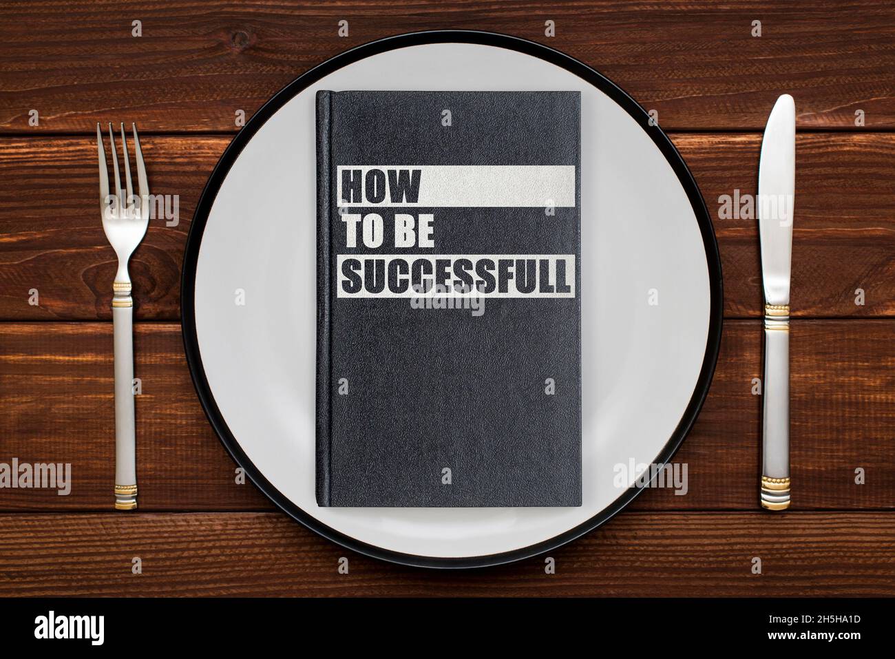 A book with the inscription HOW TO BE SUCCESSFUL on a plate. The concept of gaining knowledge, self-education Stock Photo