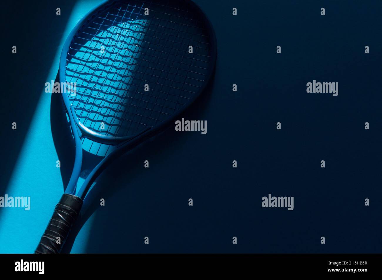 White professional  tennis racket with natural lighting on blue background. Horizontal sport theme poster, greeting cards, headers, website and app Stock Photo