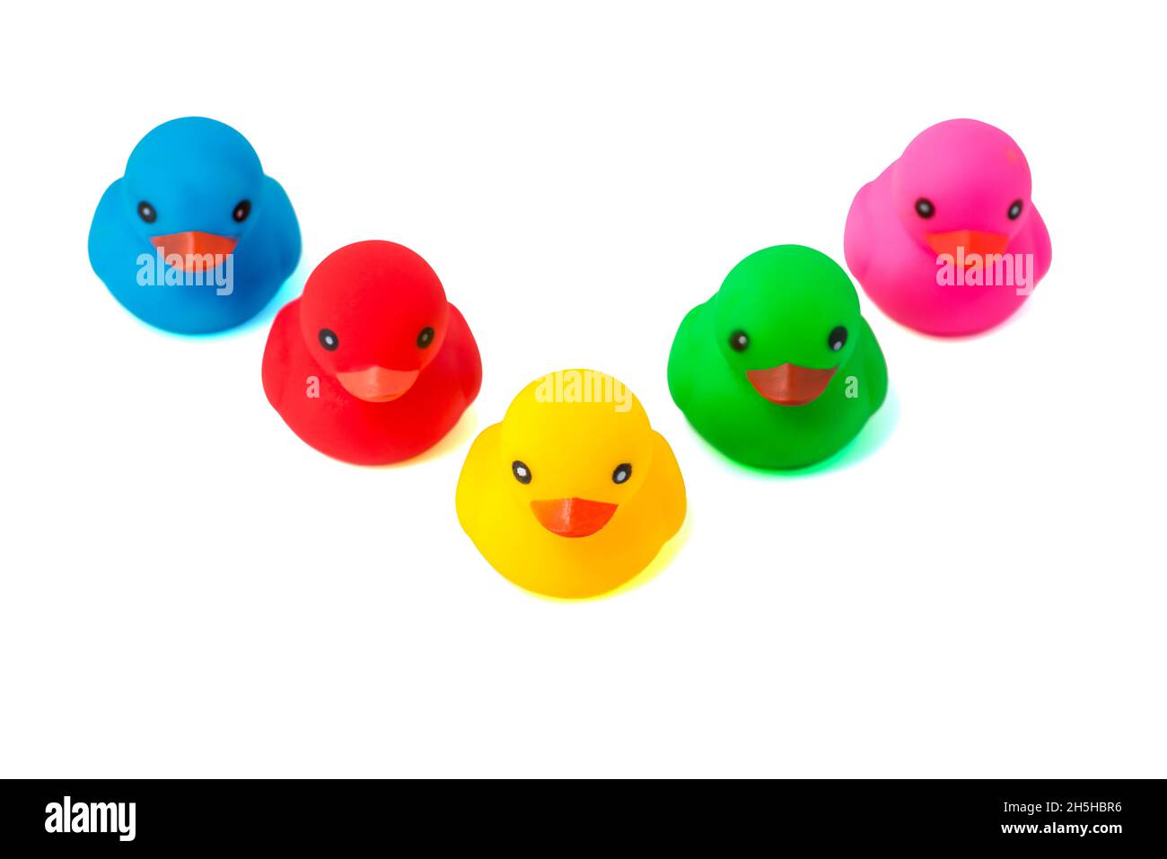 A row of rubber ducks on a white background. Bright colored rubber