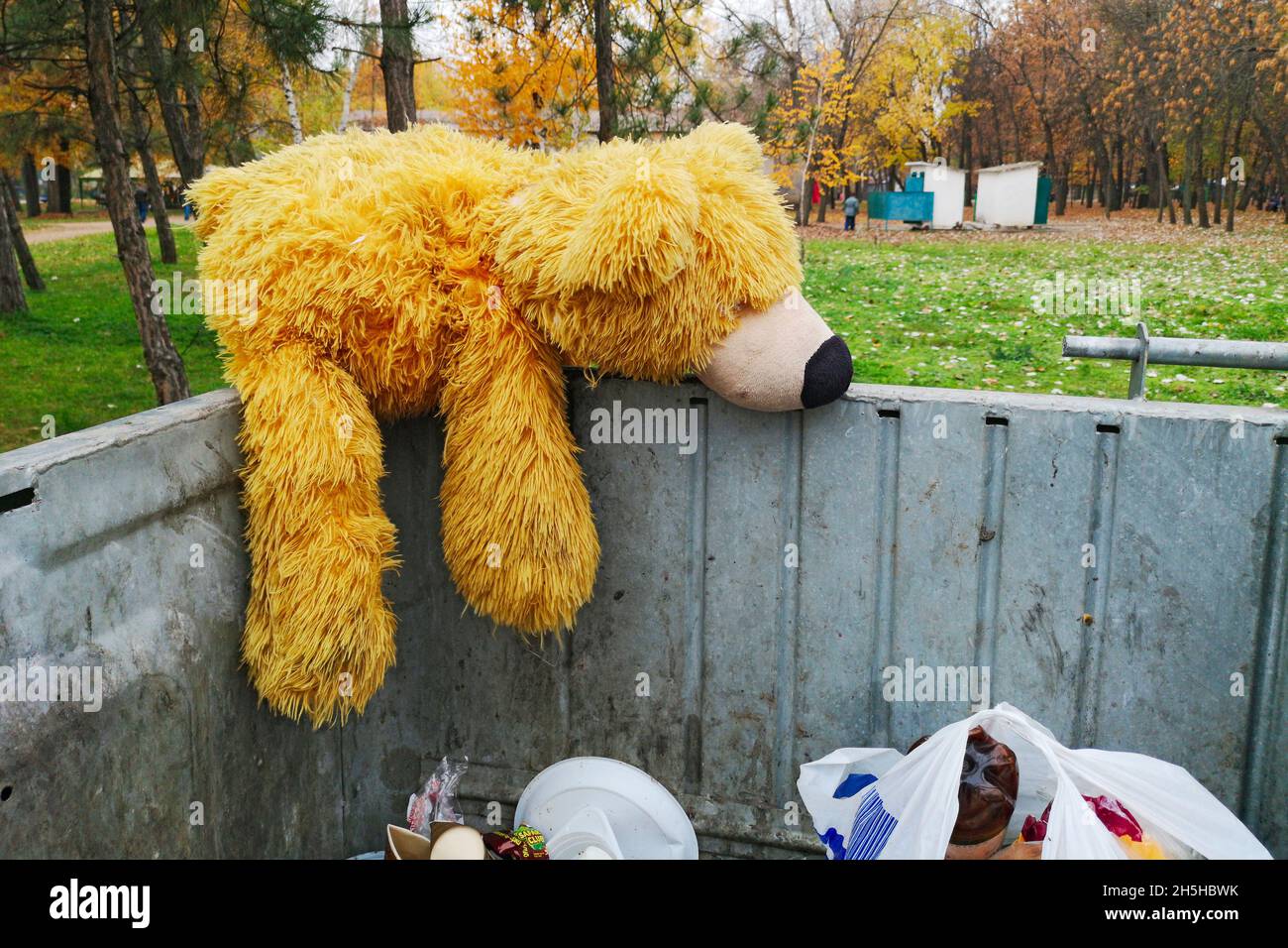 Abandoned teddy bear in the trash can. The symbol of leaving childhood, growing up Stock Photo