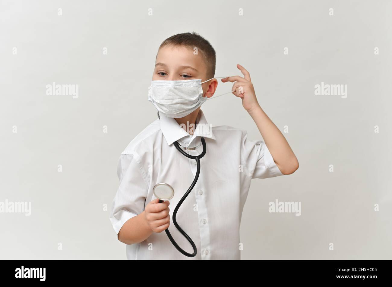 child of 8-10 years old with a phonendoscope plays doctor.  Stock Photo