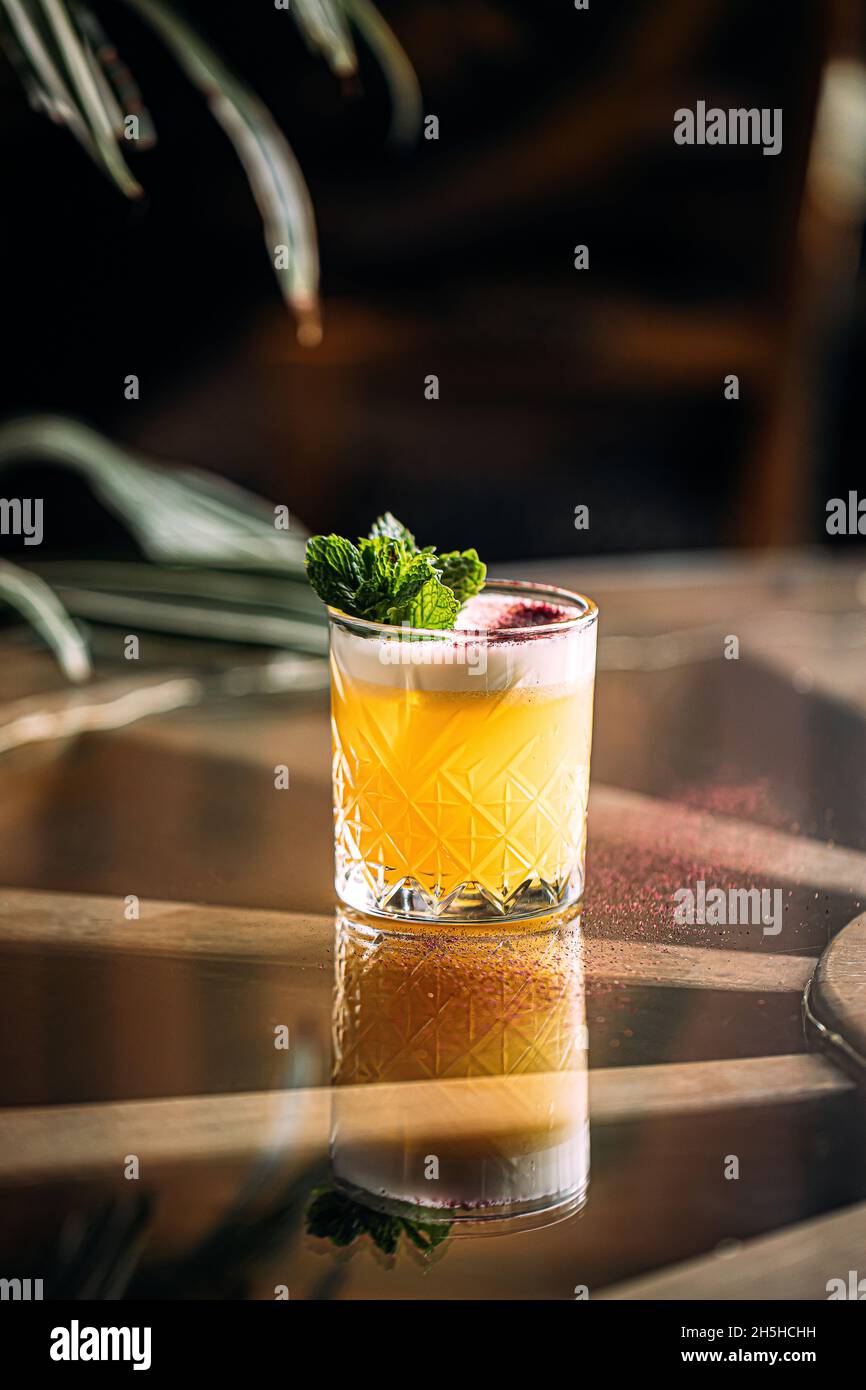 Yellow whisky sour cocktail garnished with mint Stock Photo Alamy