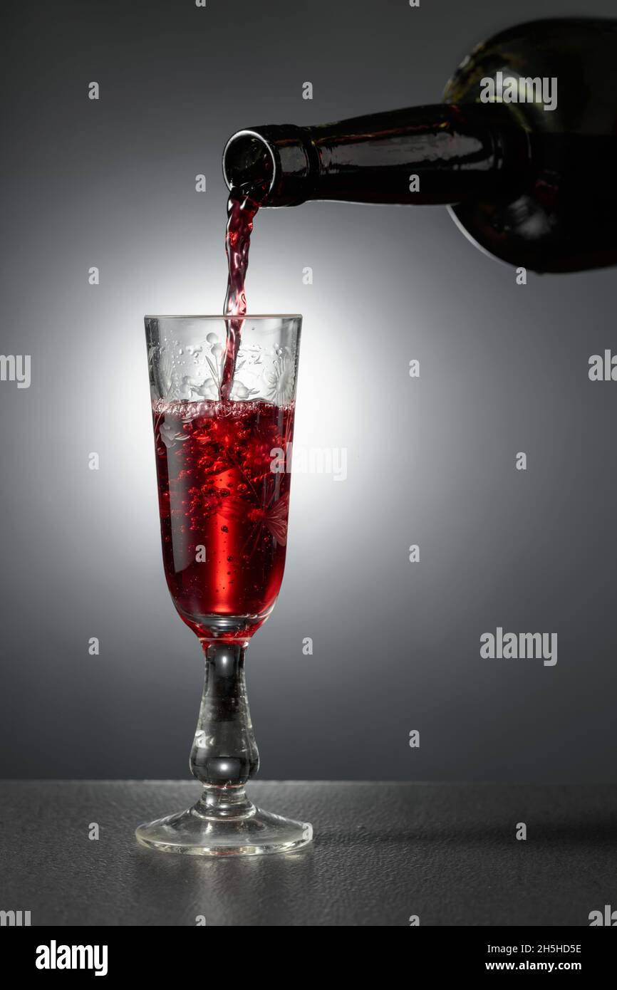 Dessert wine or liqueur is poured into a glass from an ancient bottle. Copy space. Stock Photo