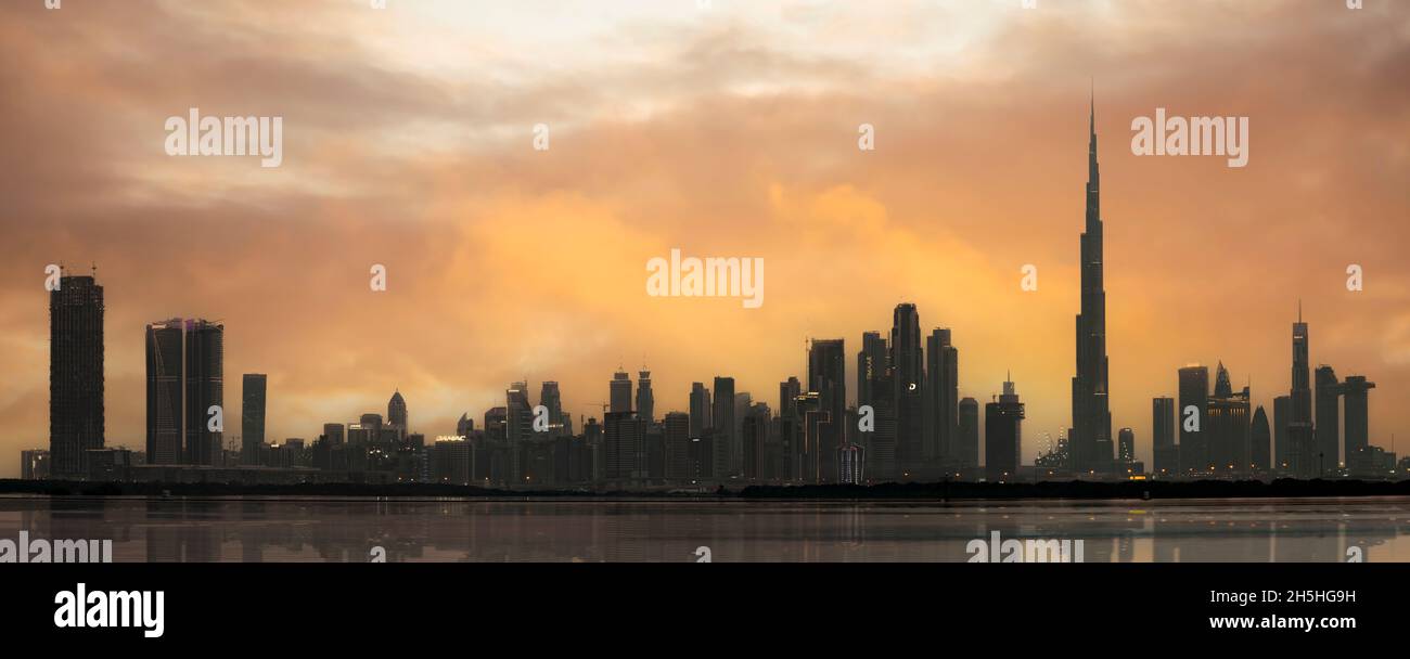 Stunning view of the silhouette of the Dubai Skyline during a dramatic sunset. Dubai, United Arab Emirates. Stock Photo