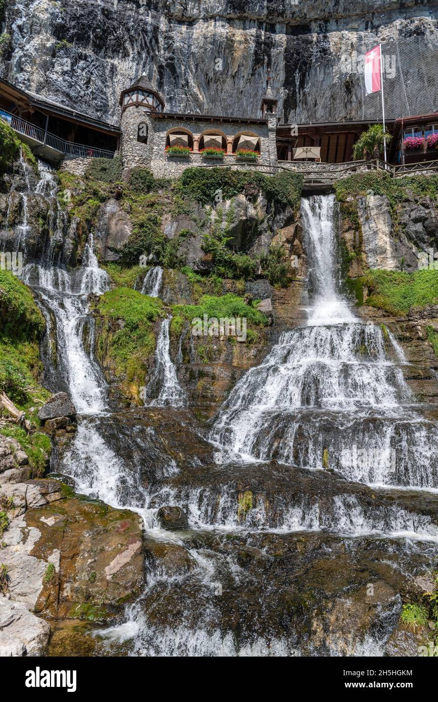 Ensemble of buildings with waterfall in front of the Saint Beatus Caves, Beatenberg, Bernese Oberland, Switzerland Stock Photo