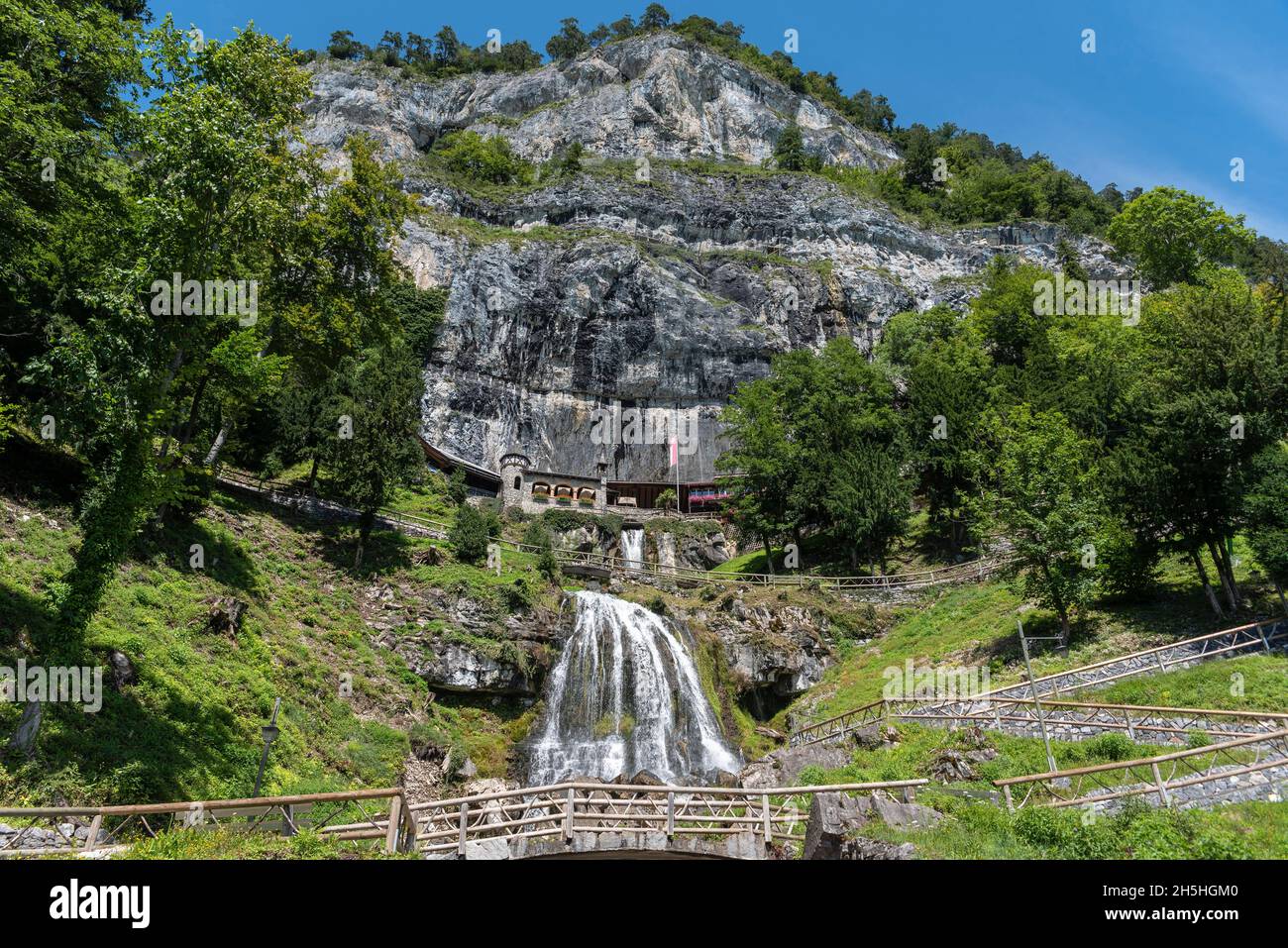 Ensemble of buildings with waterfall in front of the Saint Beatus Caves, Beatenberg, Bernese Oberland, Switzerland Stock Photo