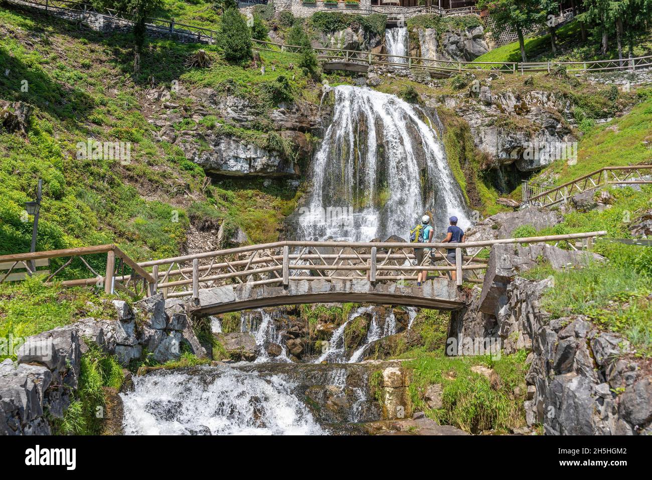 Hikers at the waterfall in front of the Saint Beatus Caves, Beatenberg, Bernese Oberland, Switzerland Stock Photo