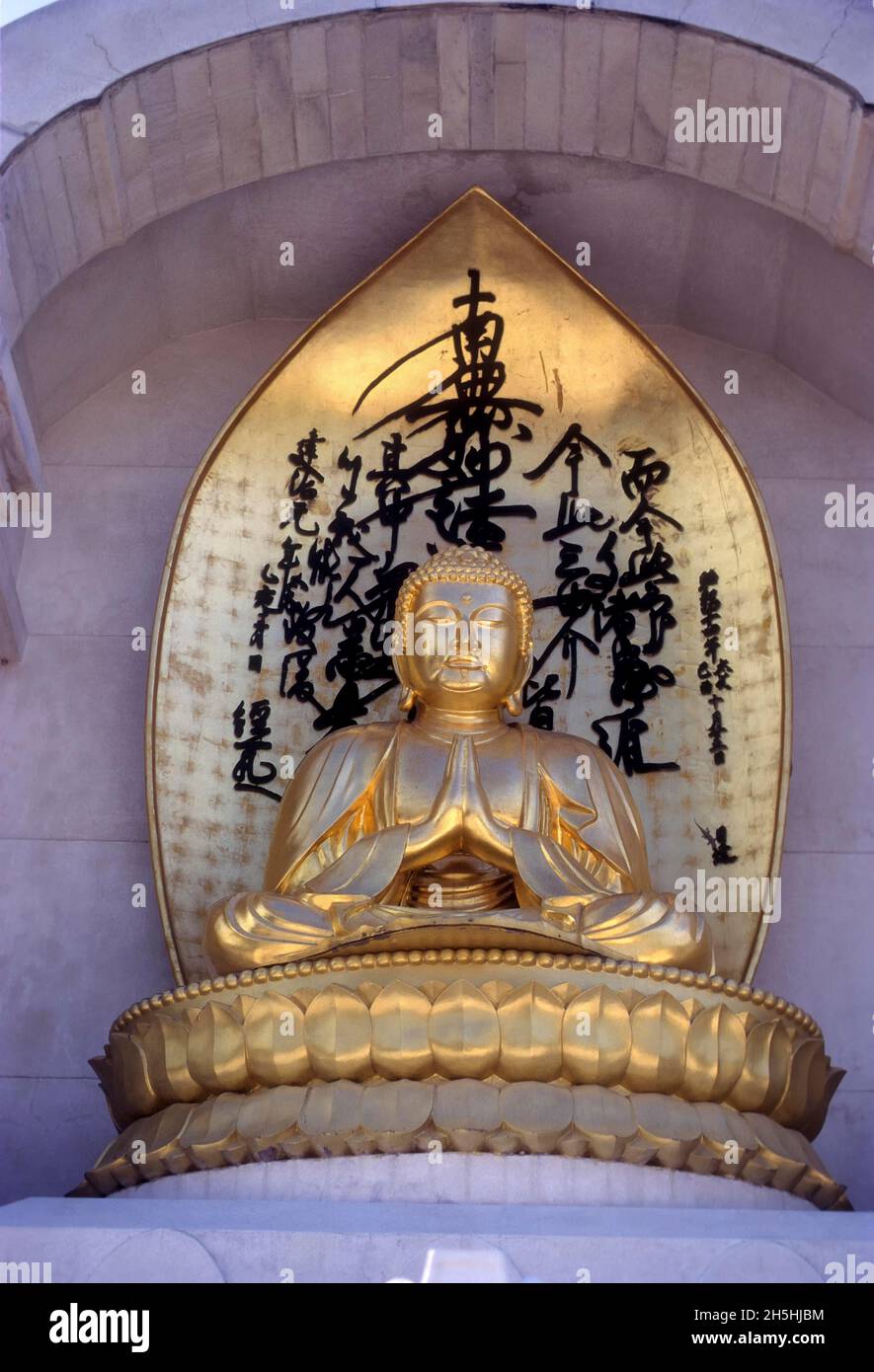 Gilded statue of Buddha on Vishwa Shanti Stupa, Rajgir, Bihar, India Stock Photo