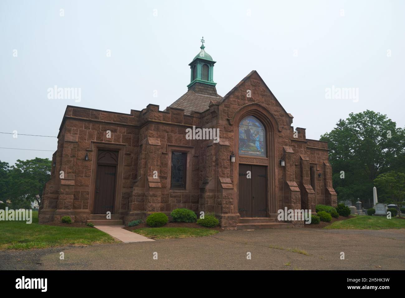 A red sandstone building, temple with stained glass. The Jewish