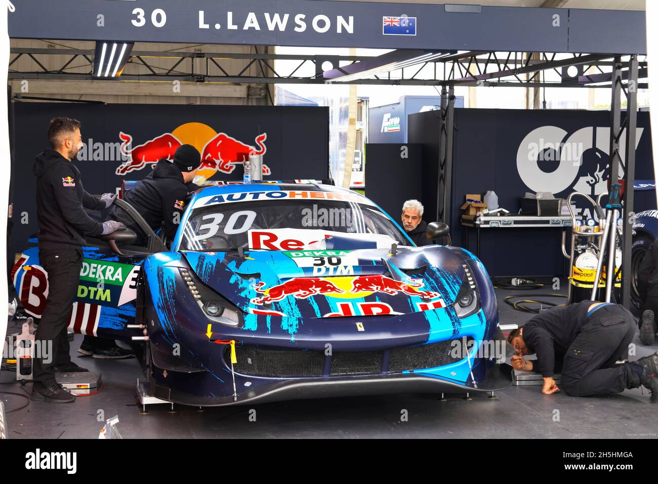 Mechanics work in pit, pit lane on DTM race car, German Torenwagen Masters, by New Zealand race car driver Liam Lawson, Red Bull AF Corse Ferrari 488 Stock Photo