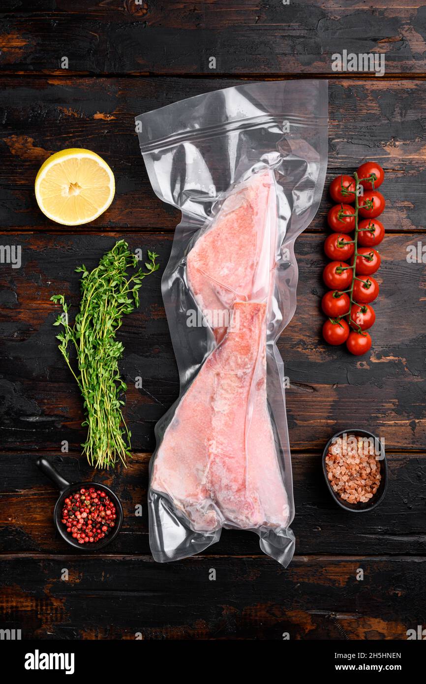 Perch frozen fish meat pack set, with herbs, on old dark wooden table ...
