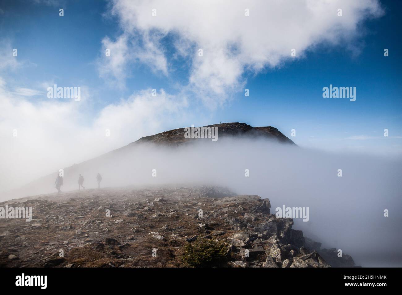 Group of people in the fog on the mountain trail, Pieniny National Park Tourist come out of thick fog at cloud level on mountain trail Amazing weather Stock Photo