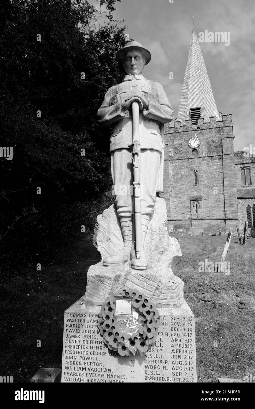World War One British or Commonwealth soldier at prayer with rifle reversed, statue in stone in an English village churchyard. Stock Photo