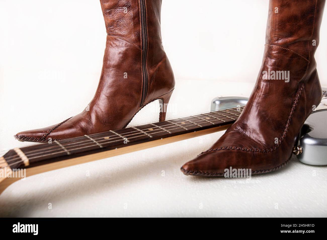 Silver electric guitar and brown women's high heels boots Stock Photo Alamy