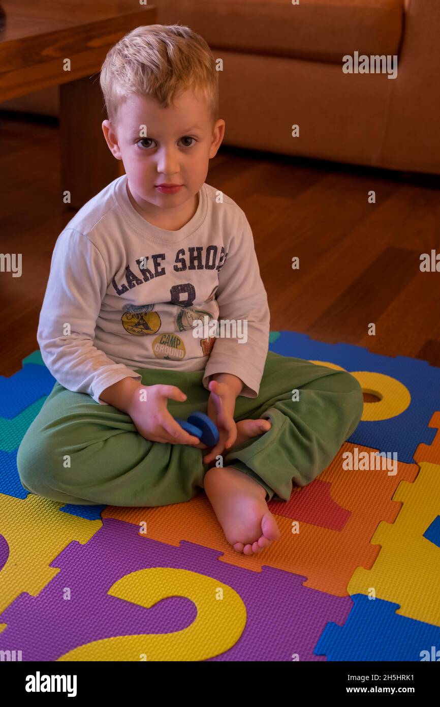 Cute creative and curious little boy playing with his toy's Stock Photo