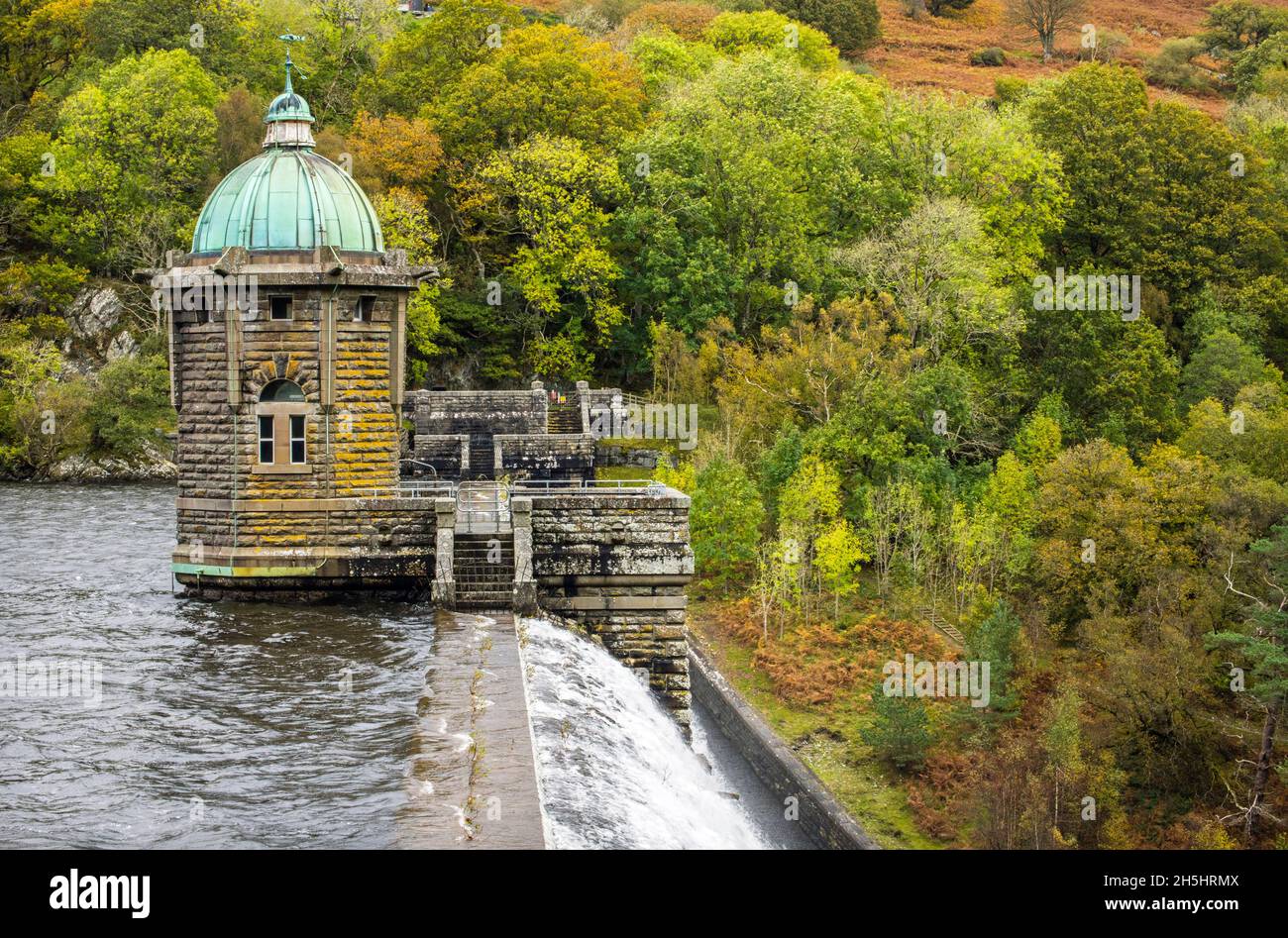 A view of the Pen y Garreg Dam in the Elan Valley in October with water flowing over the top Stock Photo
